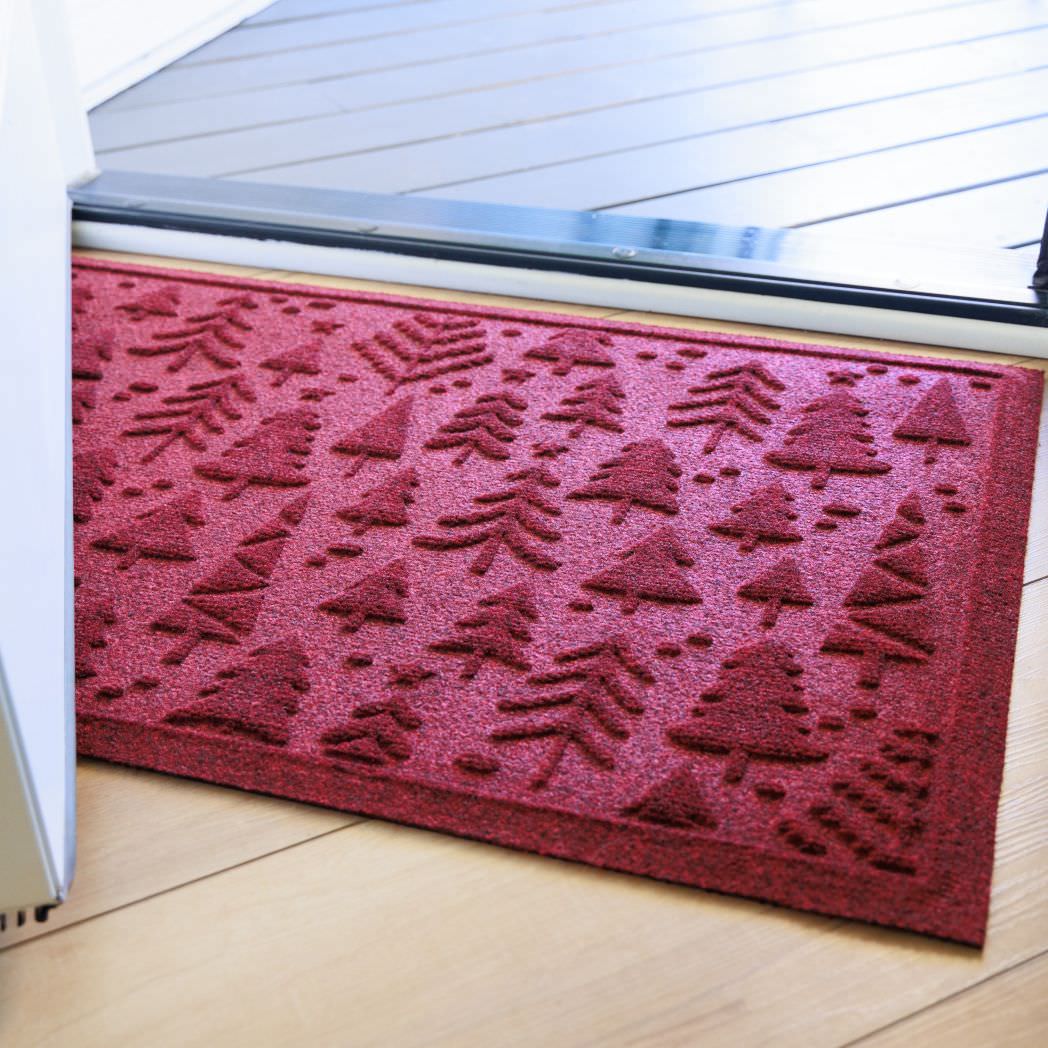 Rich red WaterHog doormat with bi-level tree pattern on a wooden floor inside front door.