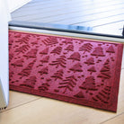 Rich red WaterHog doormat with bi-level tree pattern on a wooden floor inside front door.