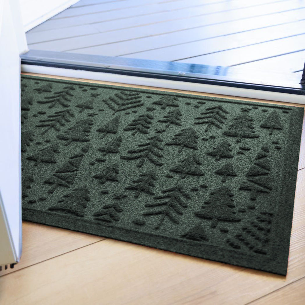 Green WaterHog doormat with tree pattern on a wooden floor inside a front door.