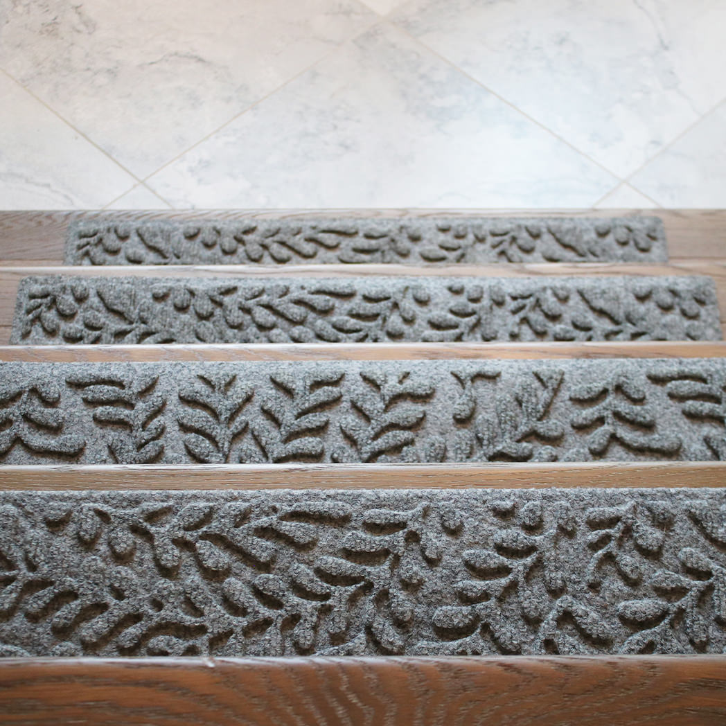 A looking-down perspective over four medium grey Boxwood stair treads on wooden stairs.