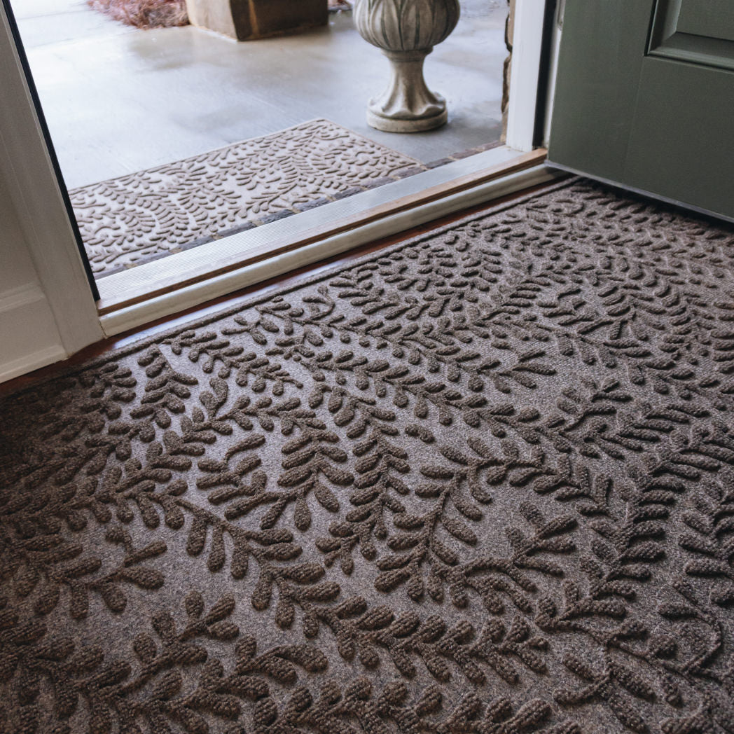 Leafy/viney textured matching doormats inside and outside a doorway
