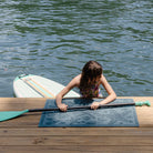 Beachcomber WaterHog mat in a beachy-shell design on a deck with a girl using it to get out of water