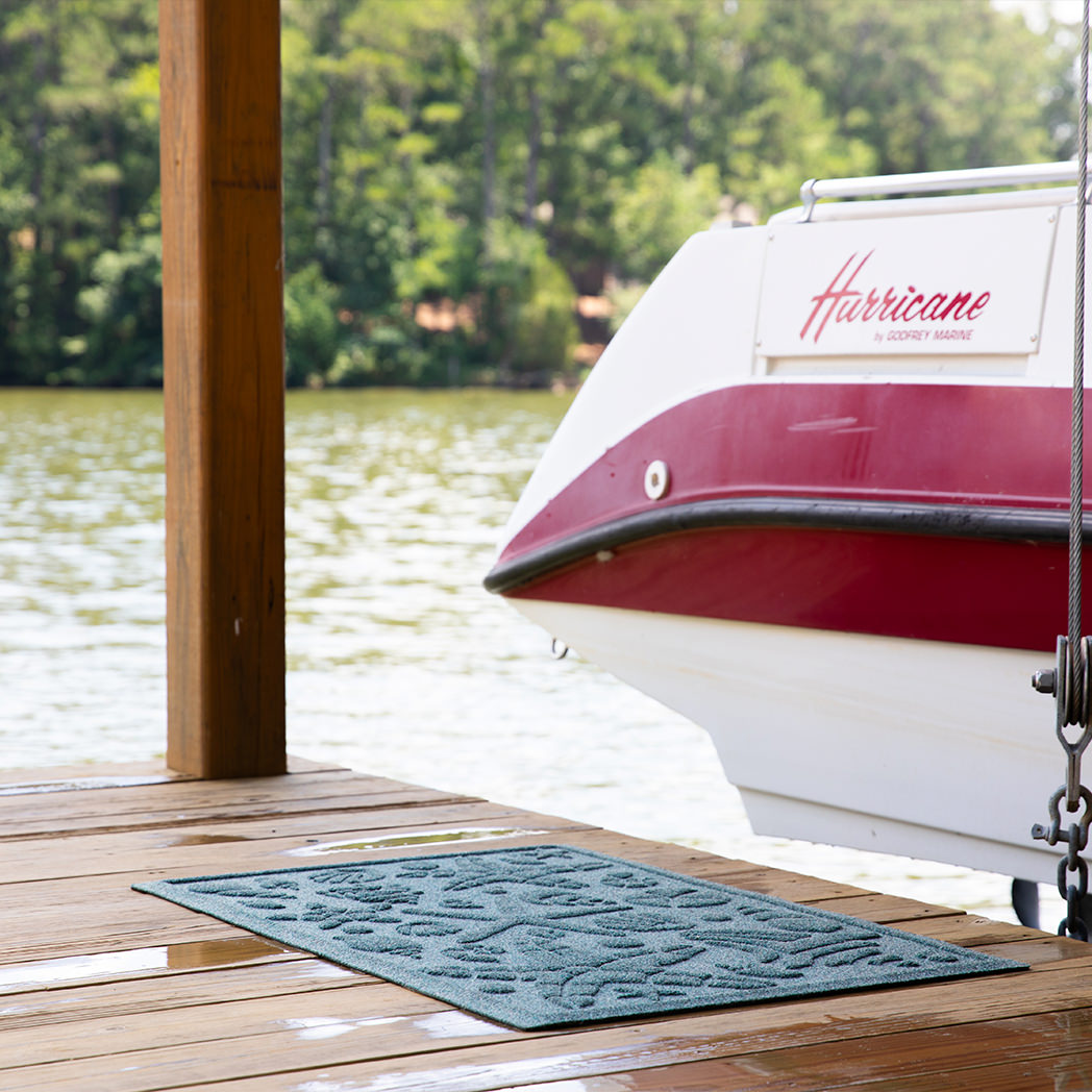 Blue beachcomber mat on a dock with a boat pulled out of water
