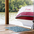 Blue beachcomber mat on a dock with a boat pulled out of water