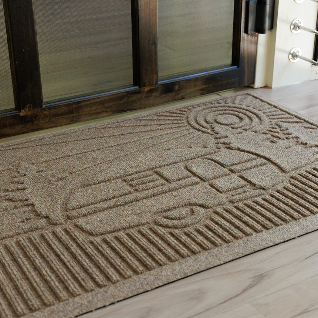 Close up of the bi-level camper design on a WaterHog doormat in front of a glass door