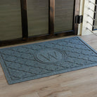 Blue monogramed Bombay doormat with the letter M at a wooden door