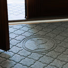 Close up of a WaterHog bi-level monogrammed doormat 'P' with a door open ajar