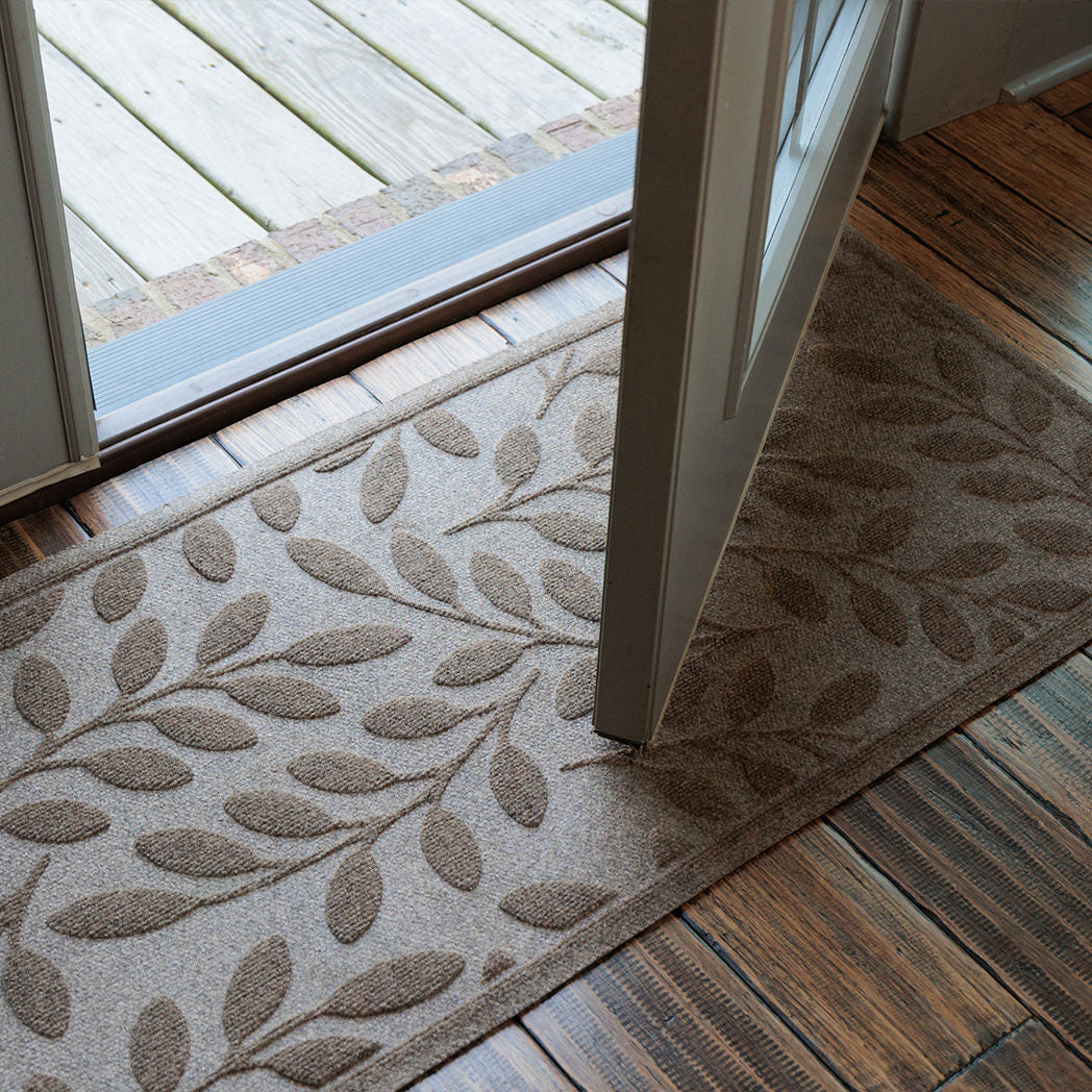 WaterHog runner with leaf pattern on wooden floor and glass door