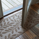 WaterHog runner with leaf pattern on wooden floor and glass door