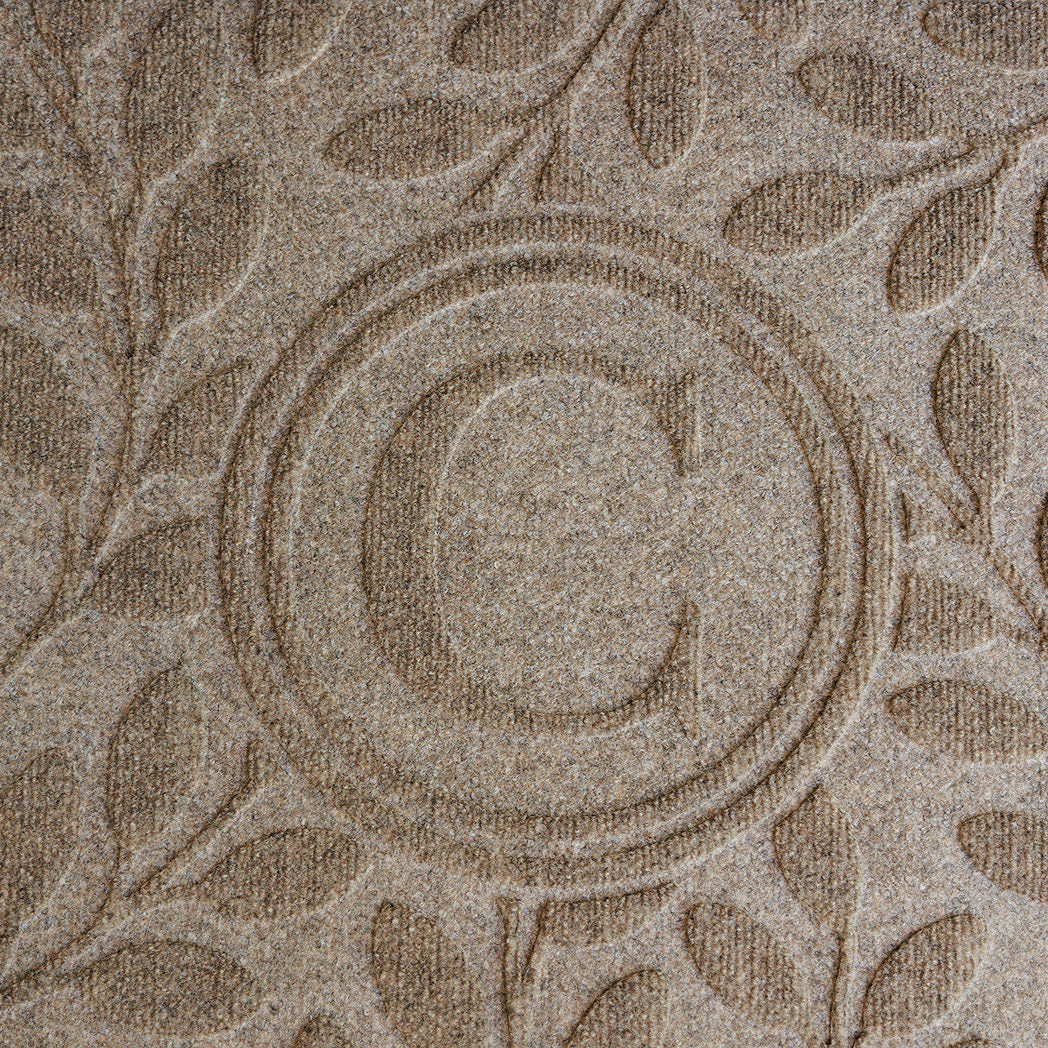 Close up of the bi-level monogrammed 'C' on a WaterHog Brittney Leaf light sand doormat