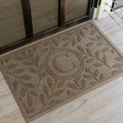 Monogrammed 'C' on a WaterHog Brittney Leaf doormat on a light wood floor