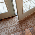 WaterHog camel-colored runner with leaf pattern at glass double doors