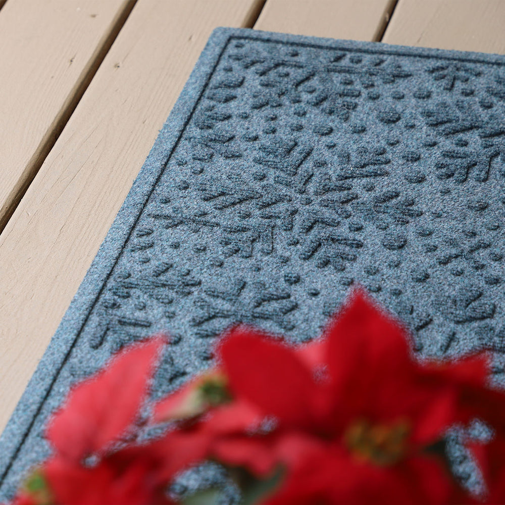 Corner-focused image of WaterHog Snowflake's bi-level design of snowflakes and dots on a front porch from tracking protection