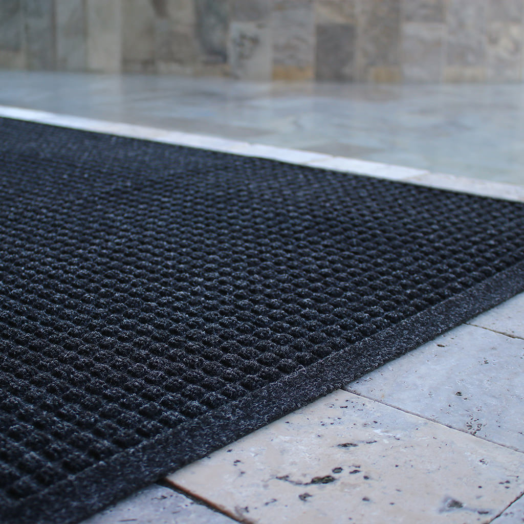 Dark charcoal WaterHog all-weather runner poolside for trapping water