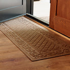 Close-up of the tan WaterHog Tristan runner mat showing its bi-level surface and raised pattern that captures dirt and moisture, shown here on light wood flooring.
