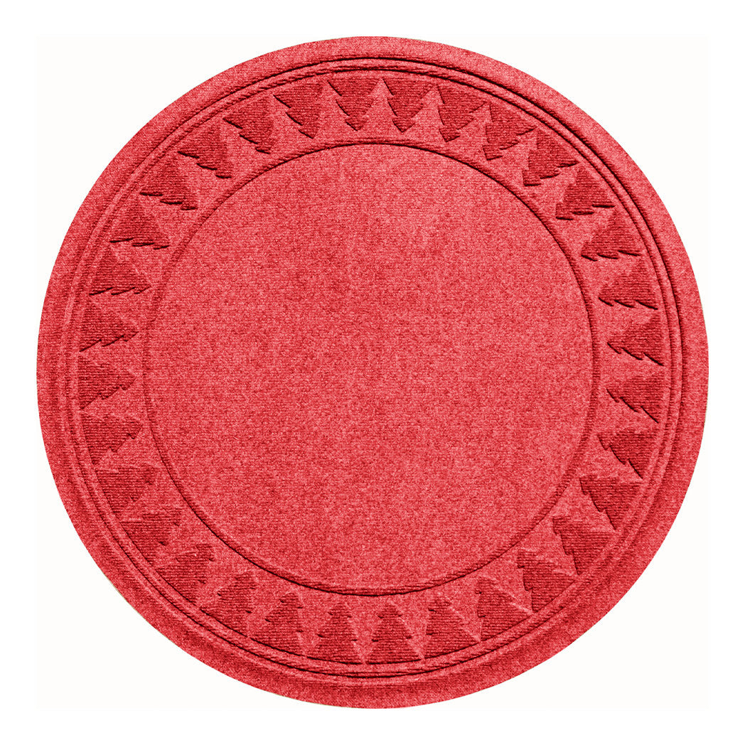 Overhead of a bright red tree skirt with a tree design on the rounded mat on a solid white background