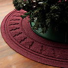 Close up a the edge of a WaterHog tree skirt in the color cranberry trapping pine needles from the tree