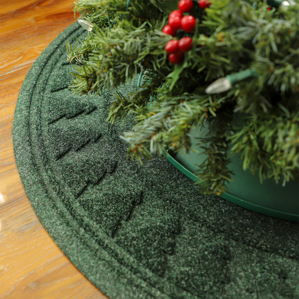 Round, deep green WaterHog tree skirt mat with a tree pattern around the rim with a water dam boarder for holding spilled water