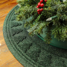 Round, deep green WaterHog tree skirt mat with a tree pattern around the rim with a water dam boarder for holding spilled water