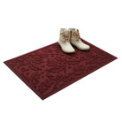 Deep red holiday doormat with white boots on a white background