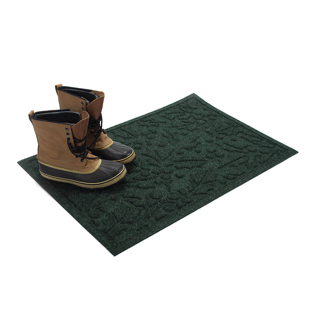 Green doormat with a pair of boots on a white background