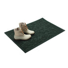 Dark green doormat with white boots on a white background