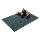 Blue doormat with a snowflake bi-level pattern  with brown boots on a white background