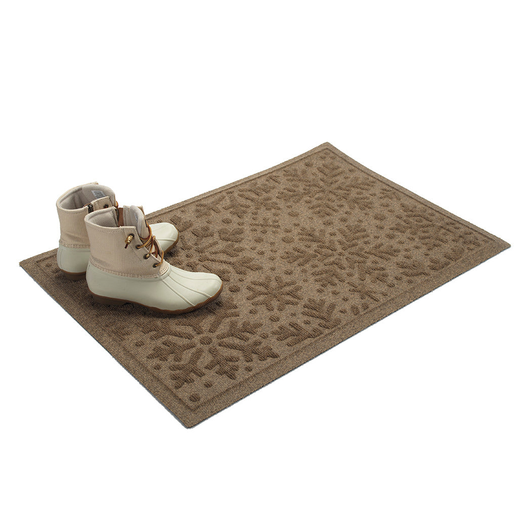 Tan doormat with snowflake pattern and white boots on a white background