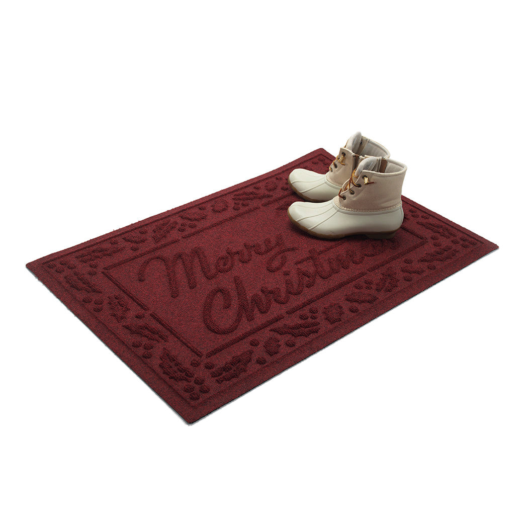 Deep red doormat with 'Merry Christmas' text and white boots on a white background