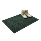 Green doormat with 'Merry Christmas' text and white boots on a white background