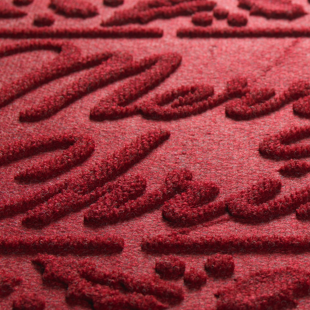 Close-up of a red Merry Christmas doormat's stain and fade-resistant surface plus the bi-level surface