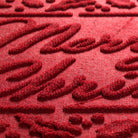 Close-up of a red Merry Christmas doormat's stain and fade-resistant surface plus the bi-level surface