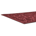 Red low-profile doormat with a textured pattern on a white background