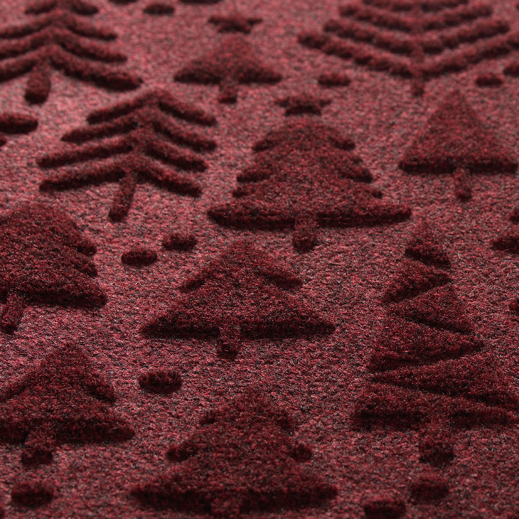 Detail shot of Tinsel Trail's bi-level design made of different style forest trees colors in a wine red