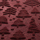 Detail shot of Tinsel Trail's bi-level design made of different style forest trees colors in a wine red