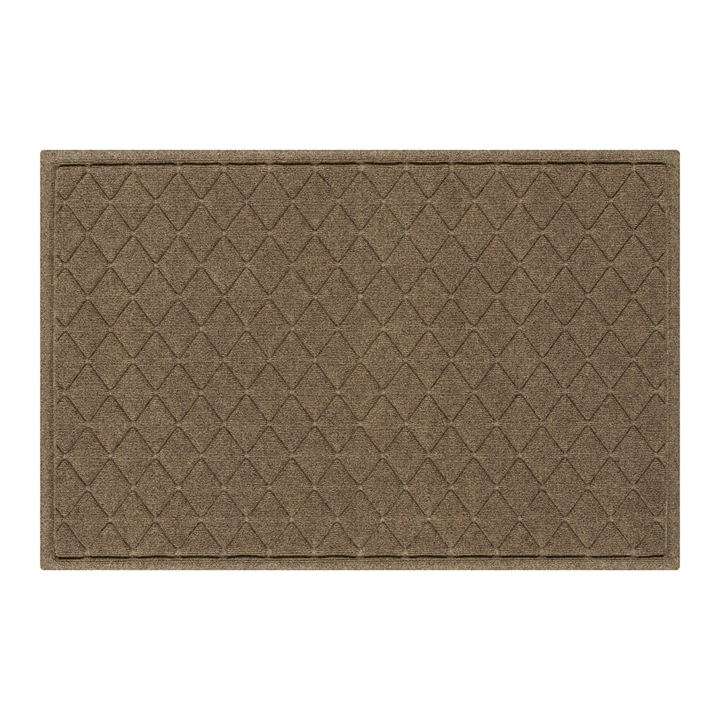 Overhead of a large WaterHog doormat in a light tan, repeating quatrefoil design; an American-made mat.