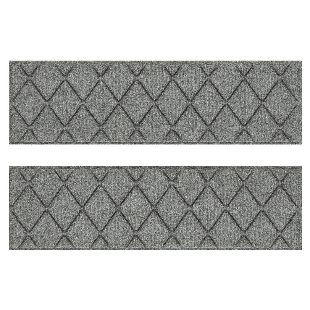 A pair of WaterHog grey indoor/outdoor stair treads are designed in an interlocking diamond pattern that is bi-level for maximum shoe scraping.