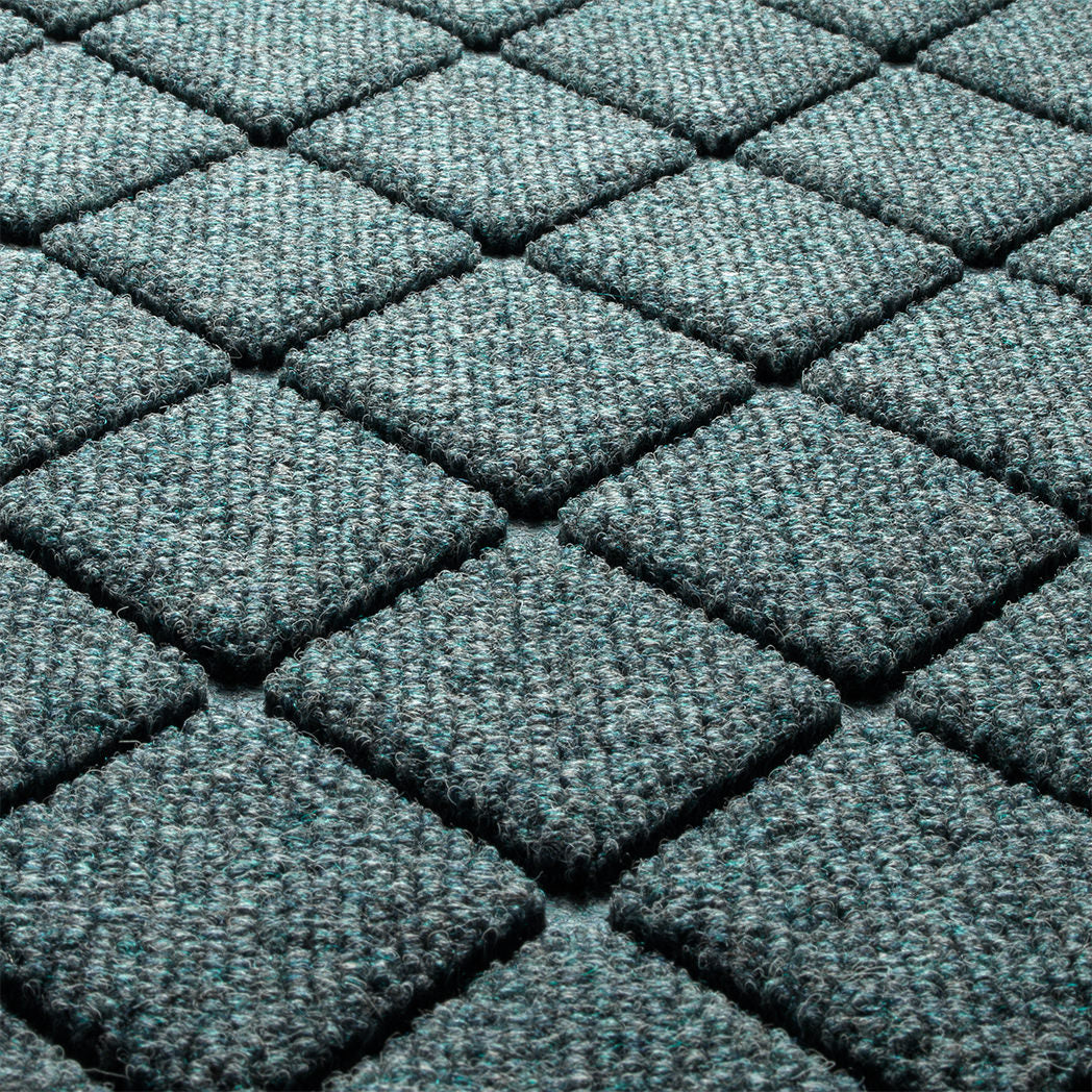 Close-up of Argyle's eco-friendly surface, made of light blue, grey, and white fibers in repeating shapes, raised diamonds for effective scraping.