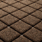Detail shot of Argyle's surface made of light and dark brown, white, and black fibers, on a bi-level surface for scraping dirt and mud away.