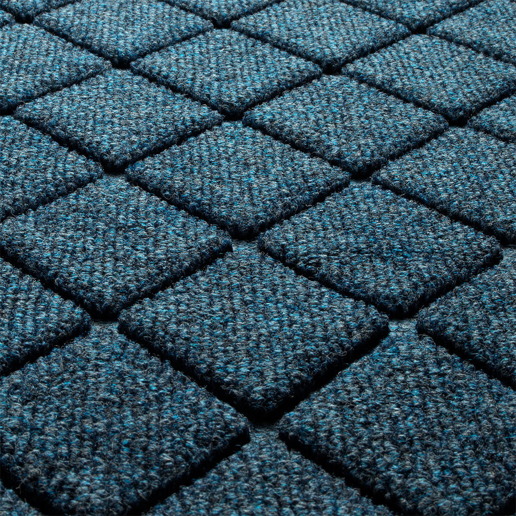 Close-up of the all-weather WaterHog durable surface made of dark and light blues, white, and grey strands, making for a fade-resistant surface.