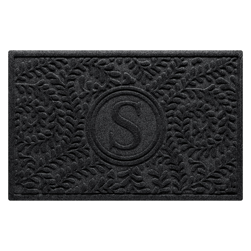 Overhead of a WaterHog 2x3 Boxwood Durable monogram doormat with a deep grey curling botanical, bi-level design.