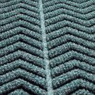 Zoomed in view of WaterHog Chevron doormat's surface detailing the bi-level zig ag pattern made of recycled PET surface in fiber colors blue, grey, and green