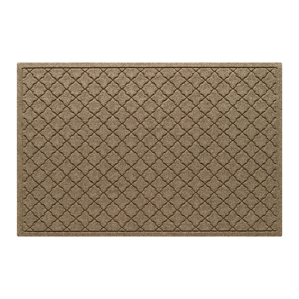 Overhead of a large WaterHog indoor/outdoor doormat in a light tan, repeating quatrefoil design; an American-made mat.