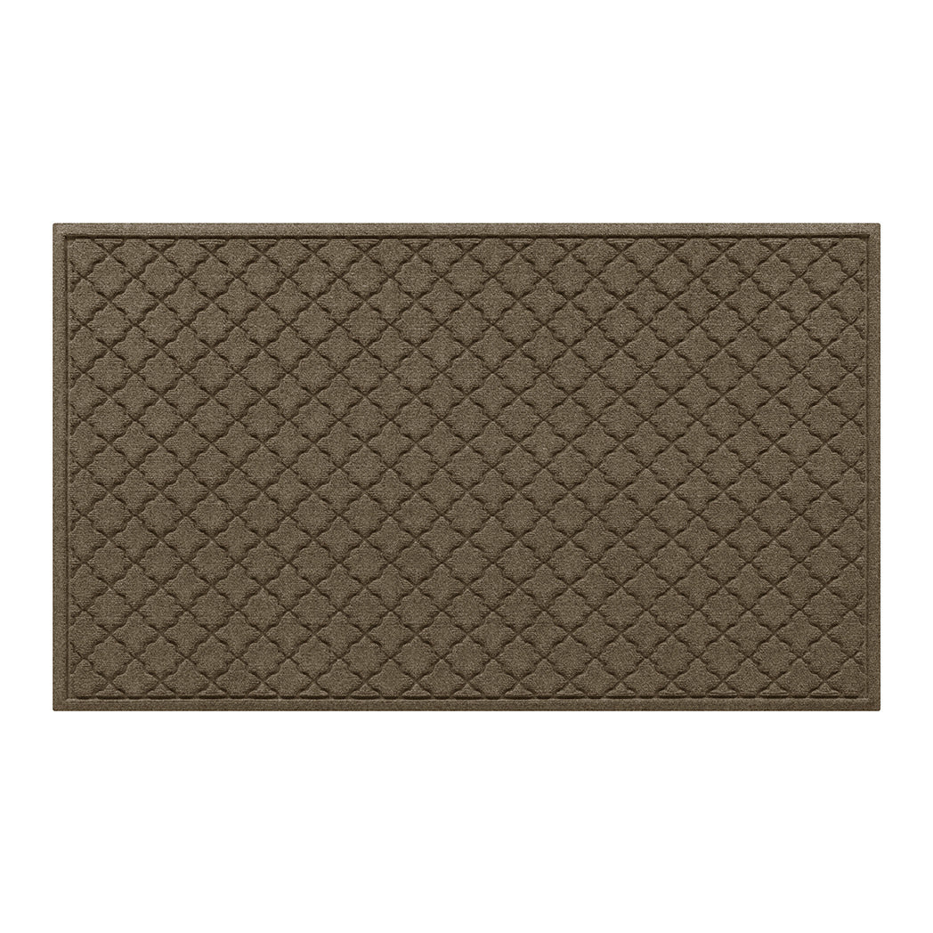 Overhead of a large WaterHog indoor/outdoor doormat in a light tan, repeating quatrefoil design; an American-made mat.