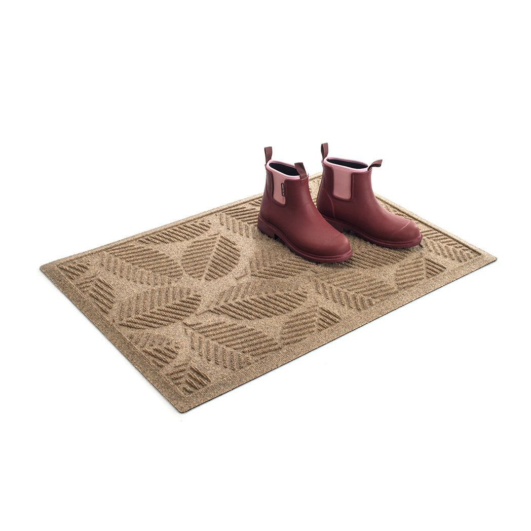 A quality WaterHog luxury half-round-doormat in camel with a pair of clean boots on the mat.