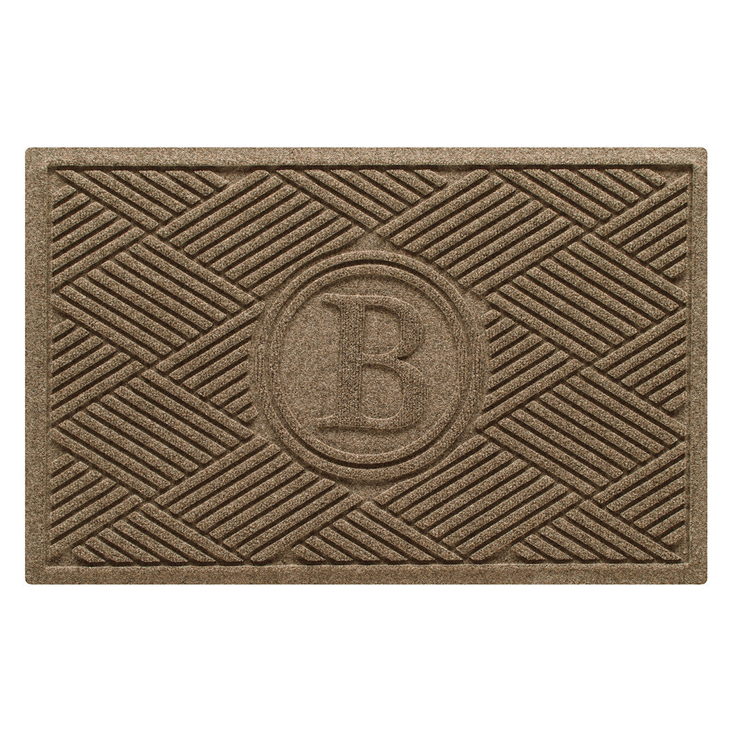 Overhead of a monogrammed Diamonds indoor/outdoor doormat with a light tan crisscrossing linear, bi-level design.