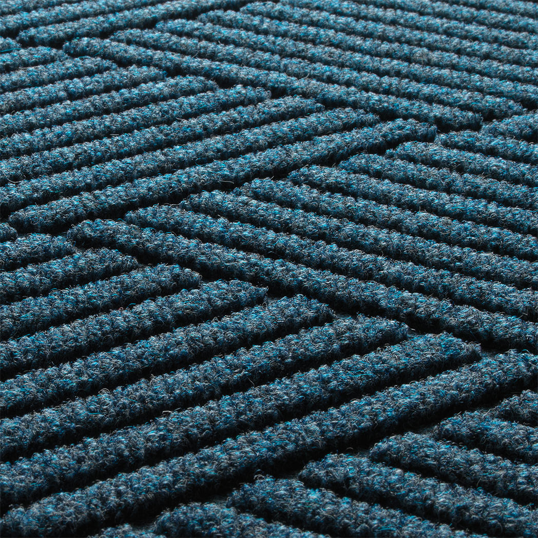 Detail image of the all-weather WaterHog durable surface made of dark and light blues, white and grey strands.