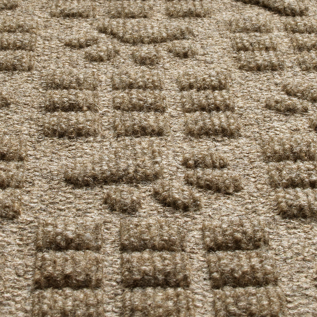 Detail shot of WaterHog's Dog Paw Squares all-weather mat in a light tan/golden color, showing its dirt-trapping, bi-level surface.