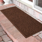Brown outdoor runner doormat with a textured pattern on a stone patio