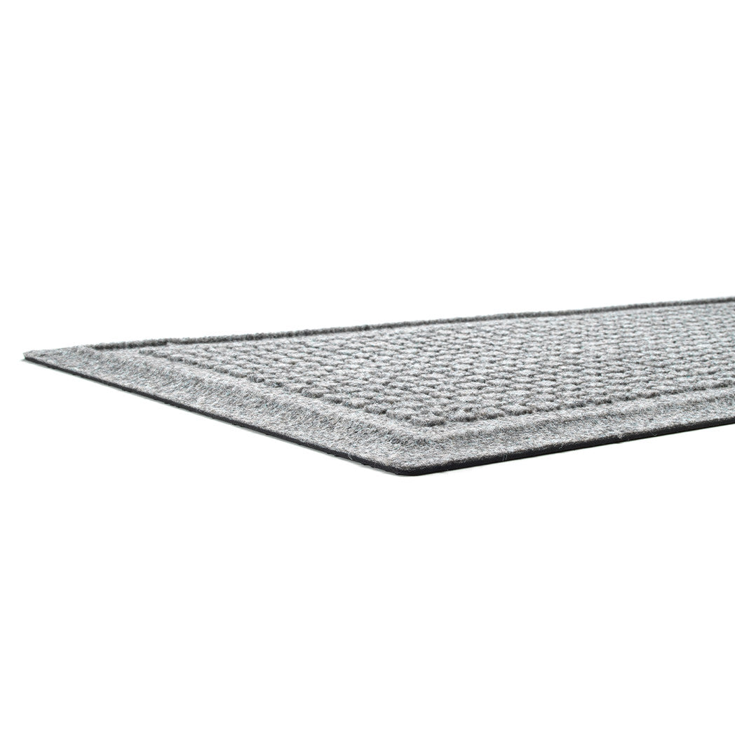 A low and close shot of grey WaterHog Squares doormat no snag, low-profile mat with an eco-friendly PET surface and durable rubber backing.